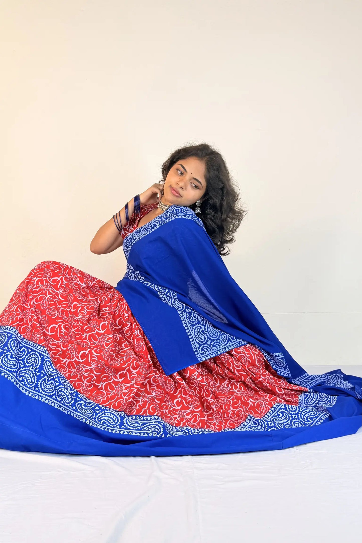 Woman wearing a blue and red Gopi Dress with a white background