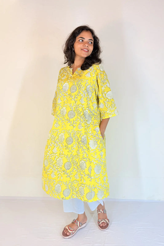 Woman wearing a yellow floral kurta against a white background