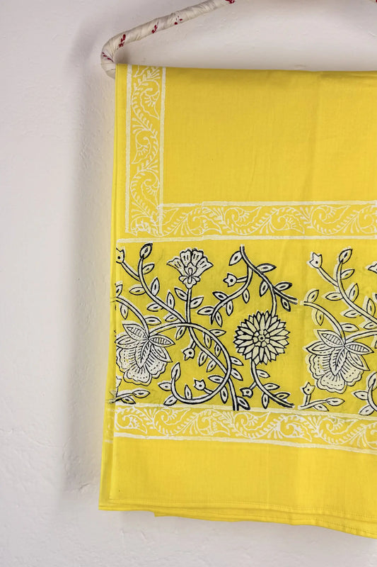Yellow fabric with black floral patterns on a white background