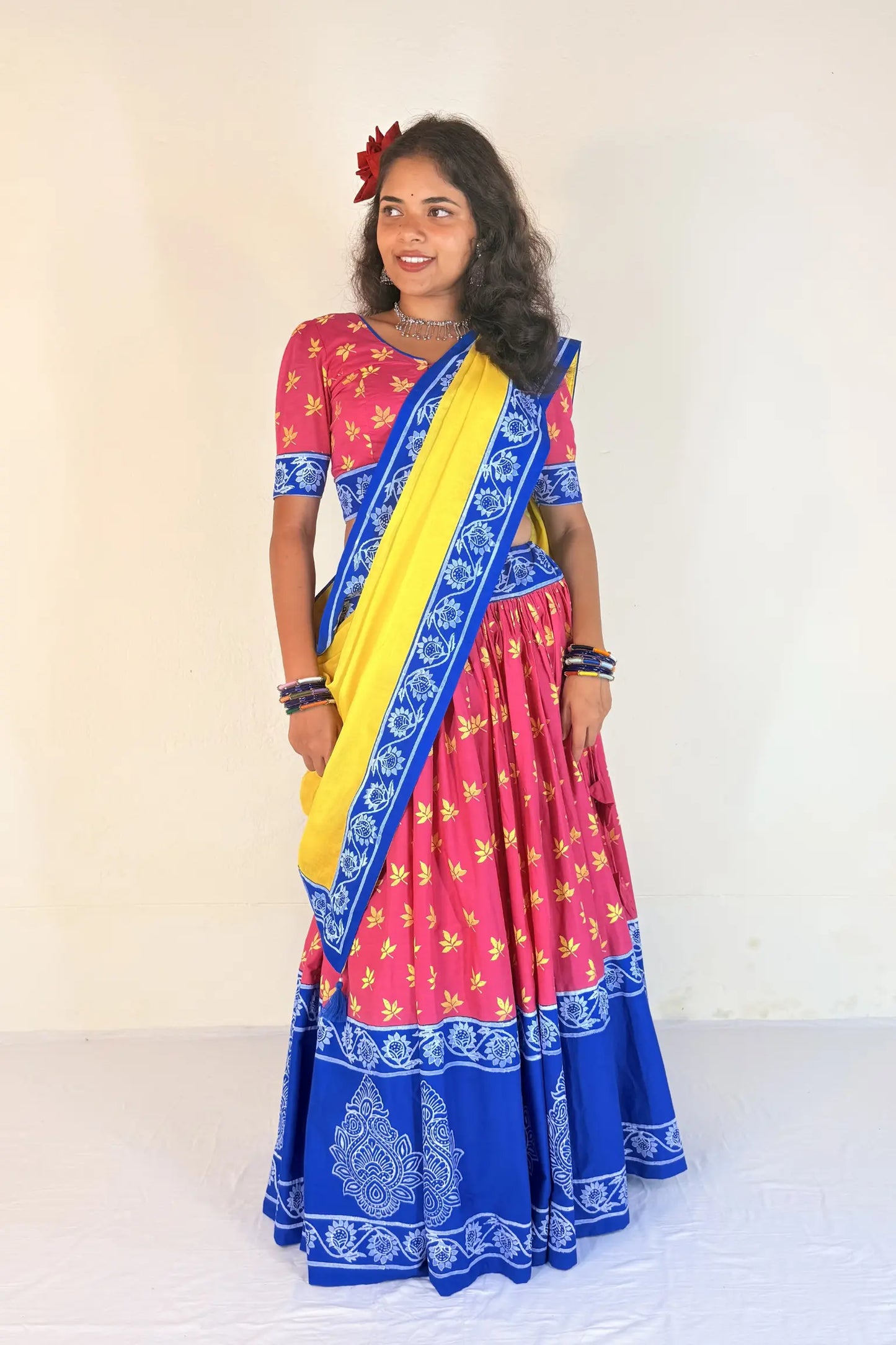 Woman wearing a colorful Gopi Dress with a pink and blue design on a white background