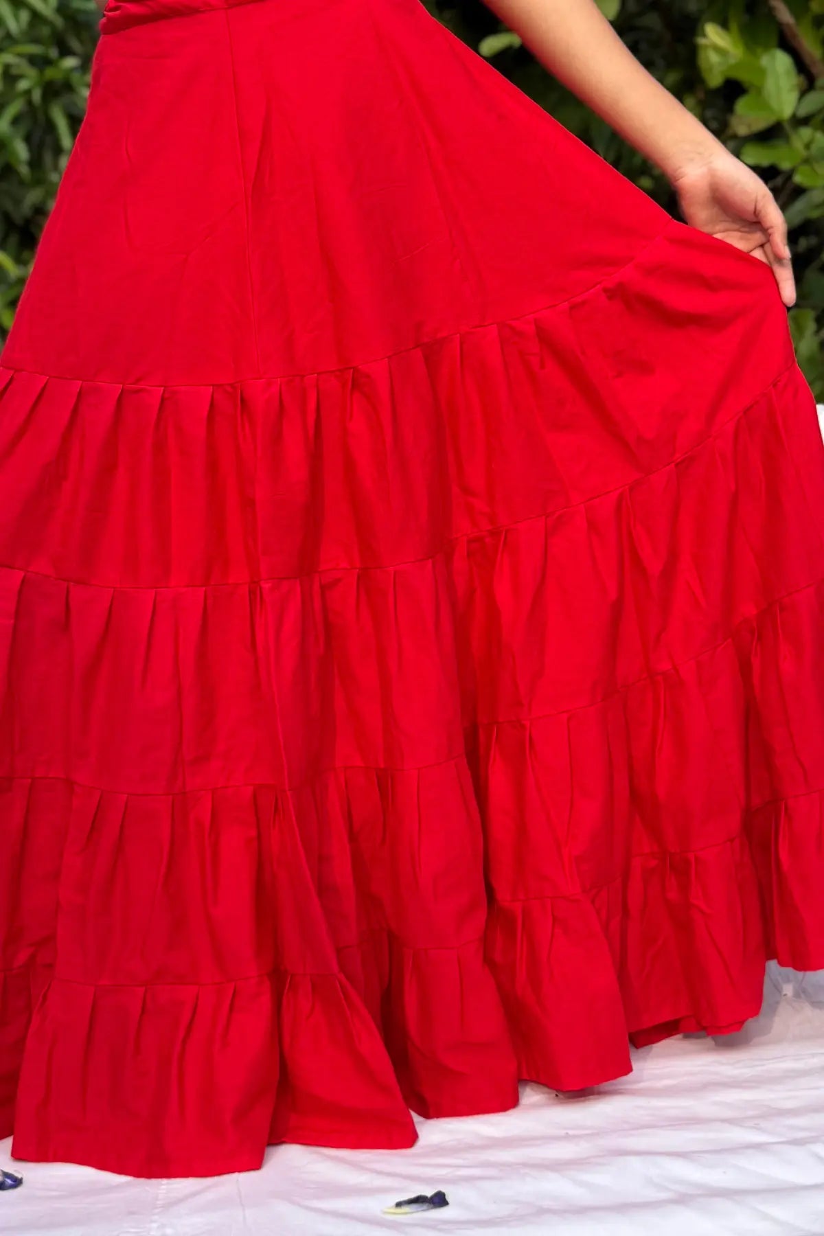 Model wearing red cotton petticoat underskirt highlighting wide flare and tiered construction outdoors