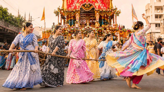 Women in brightly colored, patterned Gopi dresses joyfully pull a thick rope during a Ratha Yatra festival procession. One woman is dancing with joy. The background features a large, flower-decorated chariot and a crowded street.
