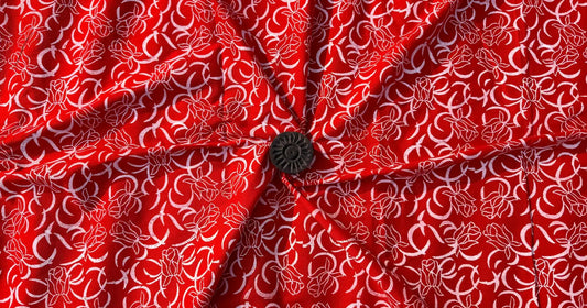 Handcrafted red fabric design inspired by unspoken love, featuring hand-printed floral patterns and human-made textures