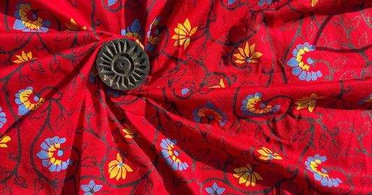 Red block-print fabric with floral motifs inspired by grandmother’s heritage, handcrafted using traditional wooden block design.