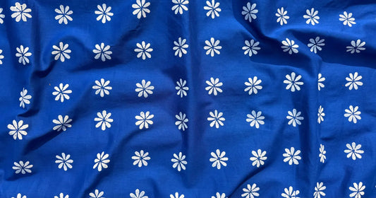 White shiuli flower motifs scattered on deep blue fabric, inspired by winter morning memories and handcrafted design by Meghambara