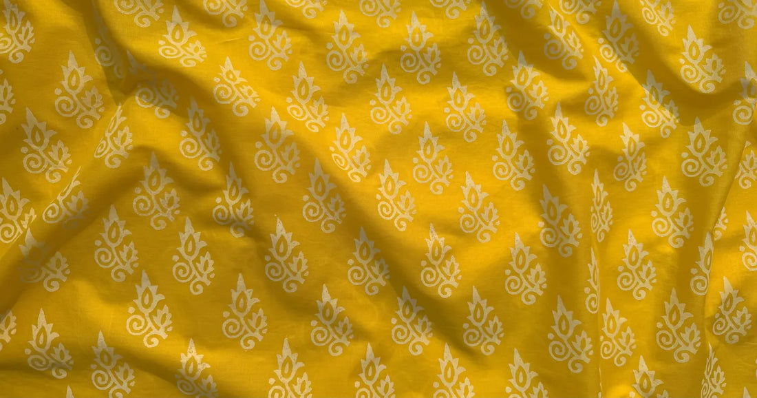 Yellow handcrafted block print fabric with white floral motifs, inspired by sunlight and traditional design.