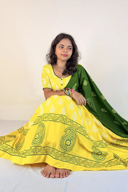Woman wearing a yellow traditional outfit with green dupatta on a white background