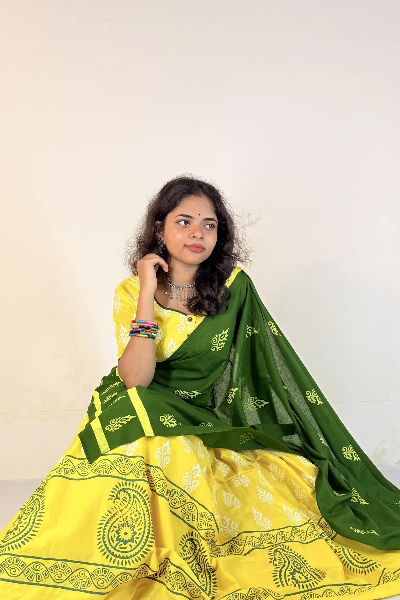 Woman wearing a yellow and green Gopi Skirt Set with a white background
