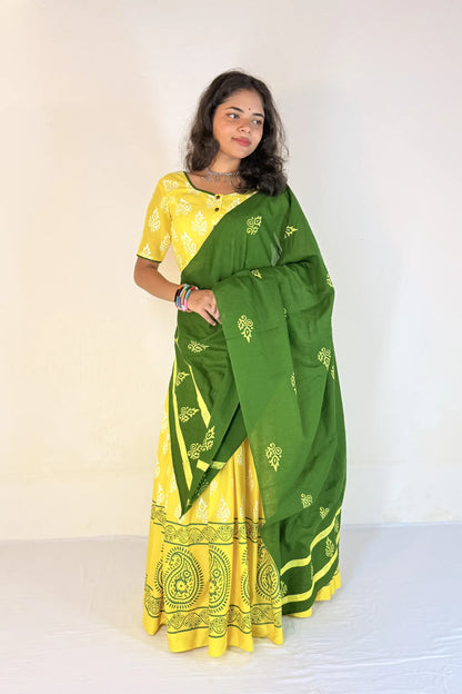 Woman wearing a green and yellow Gopi Skirt Set with a white background