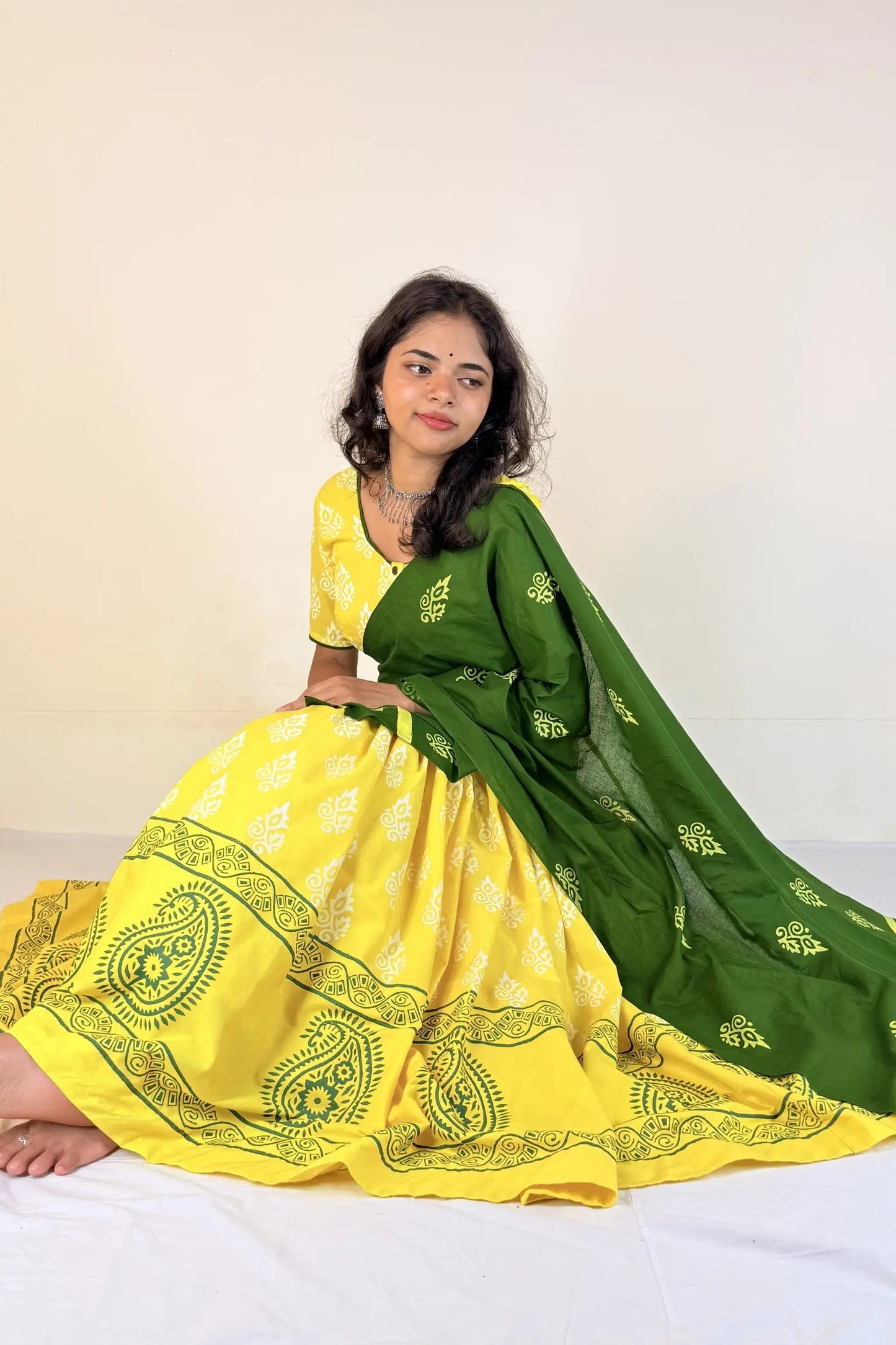 Woman wearing a yellow and green Gopi Skirt Set with a white background
