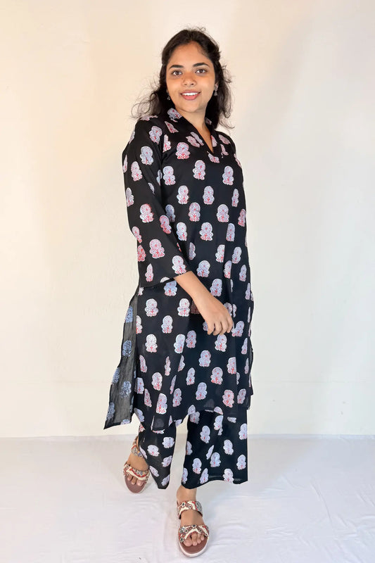 Woman wearing a black floral patterned outfit on a white background