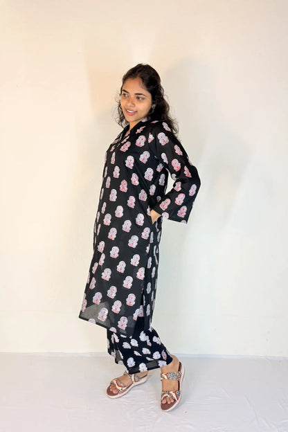 Woman wearing a black floral dress against a white background