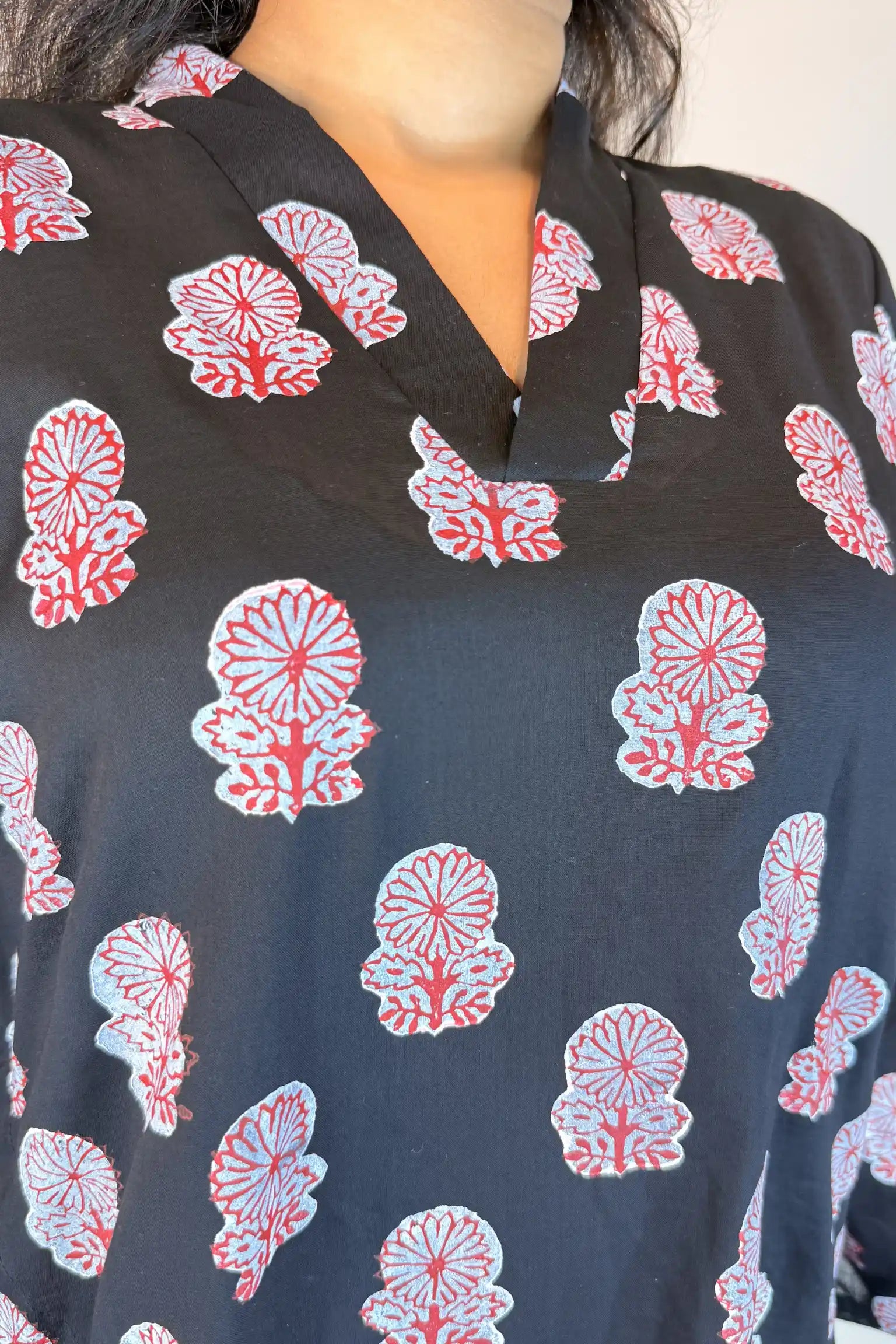 Close-up of a black garment with red and white floral patterns