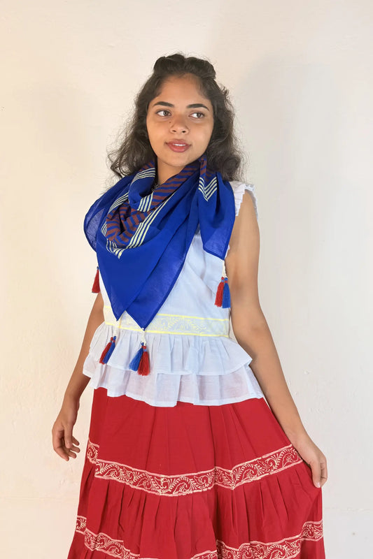 Woman wearing a traditional outfit with a red scarf and skirt on a plain background