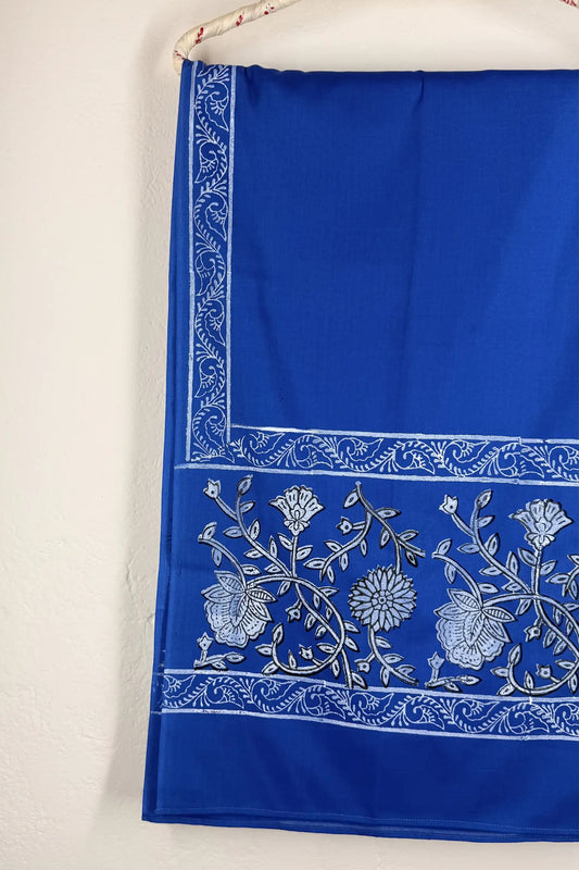Blue fabric with white floral embroidery on a white background