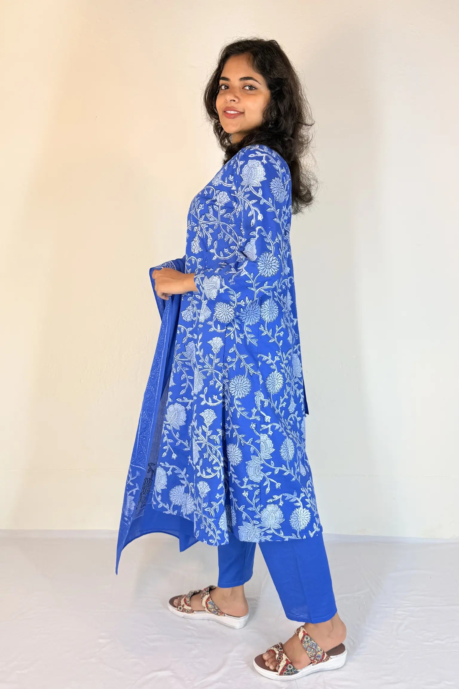 Woman wearing a blue floral kurta with matching pants against a white background
