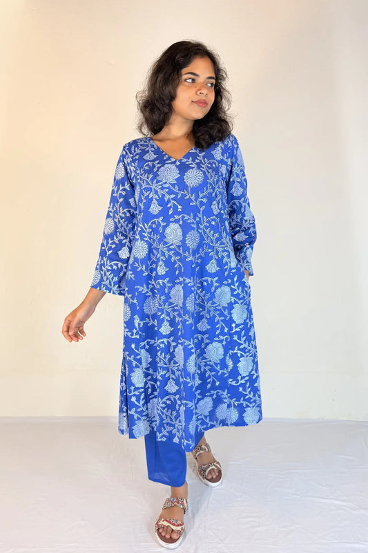 Woman wearing a blue floral dress against a plain background