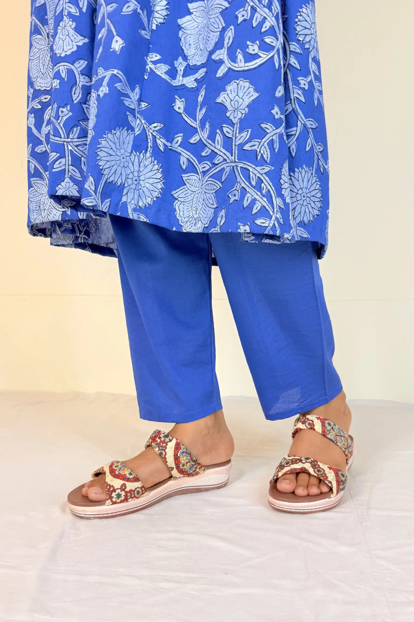 Blue floral outfit with matching pants and sandals on a white background