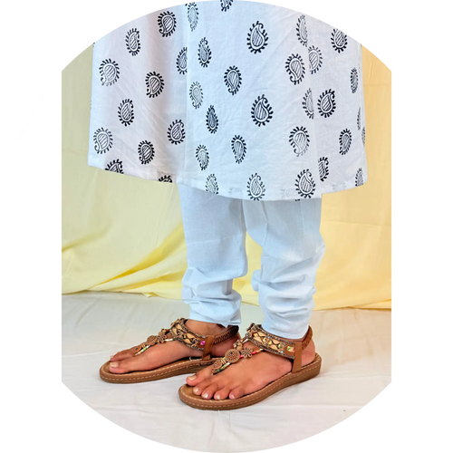 Person wearing a light blue outfit with a patterned shawl, standing on a white background