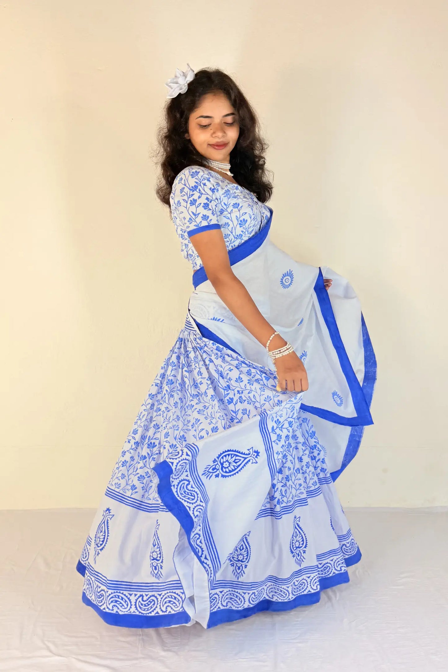 Woman wearing a purple Gopi Dress with white patterns on a plain background