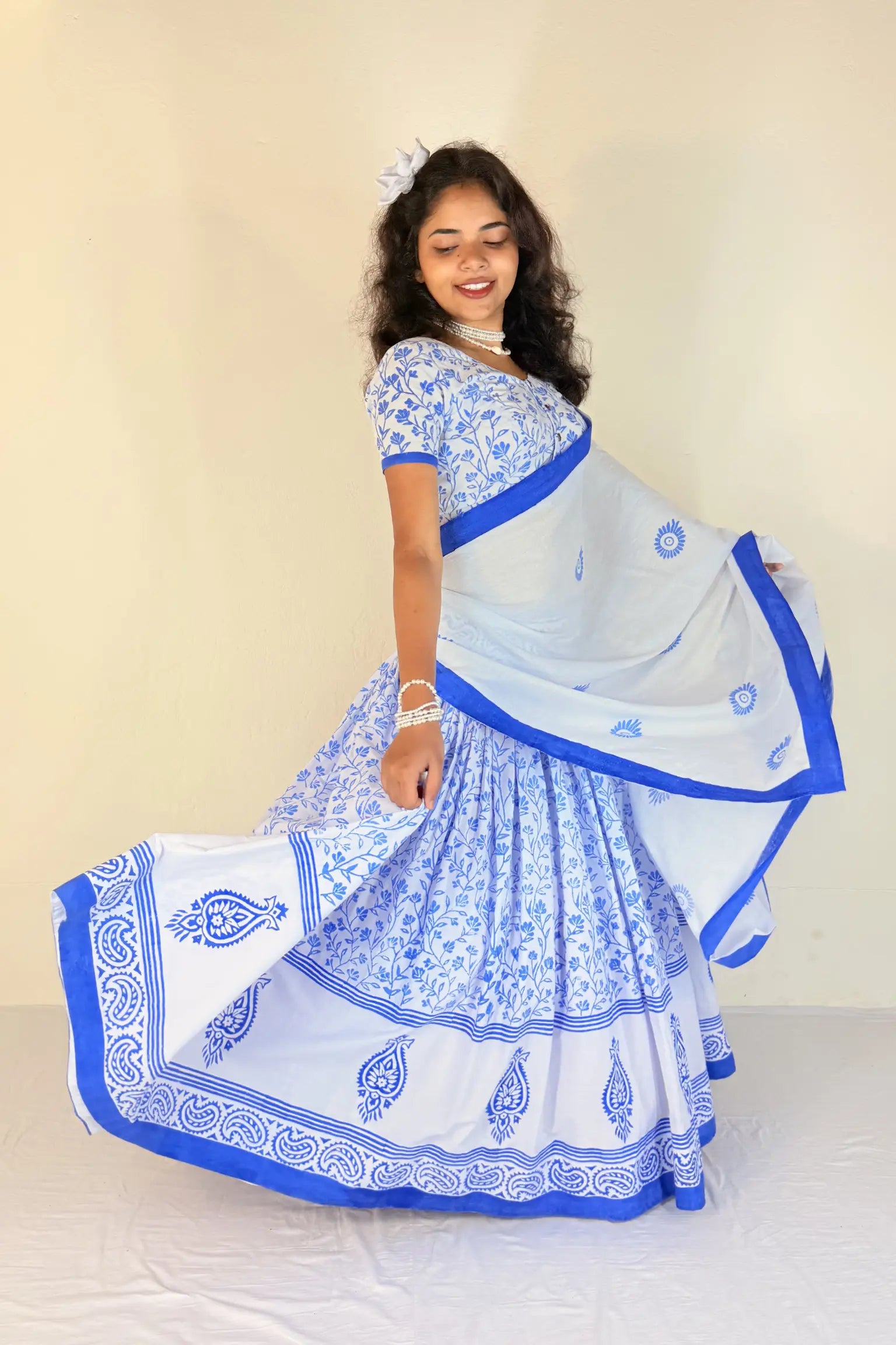 Woman wearing a traditional blue and white Gopi Dress against a plain background