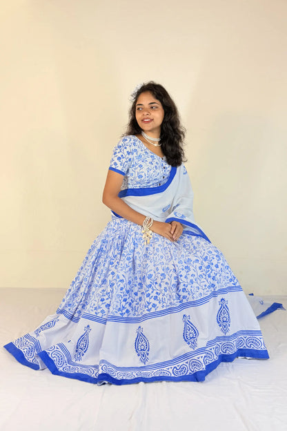 Woman wearing a blue and white traditional outfit with a plain background