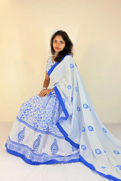 Woman wearing a white Gopi Dress with blue patterns on a beige background