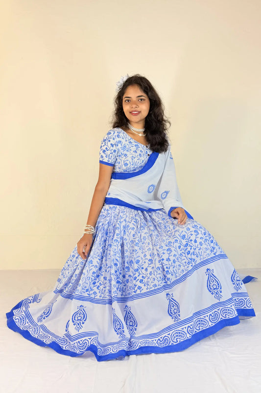 Woman wearing a white and blue traditional outfit with a plain background