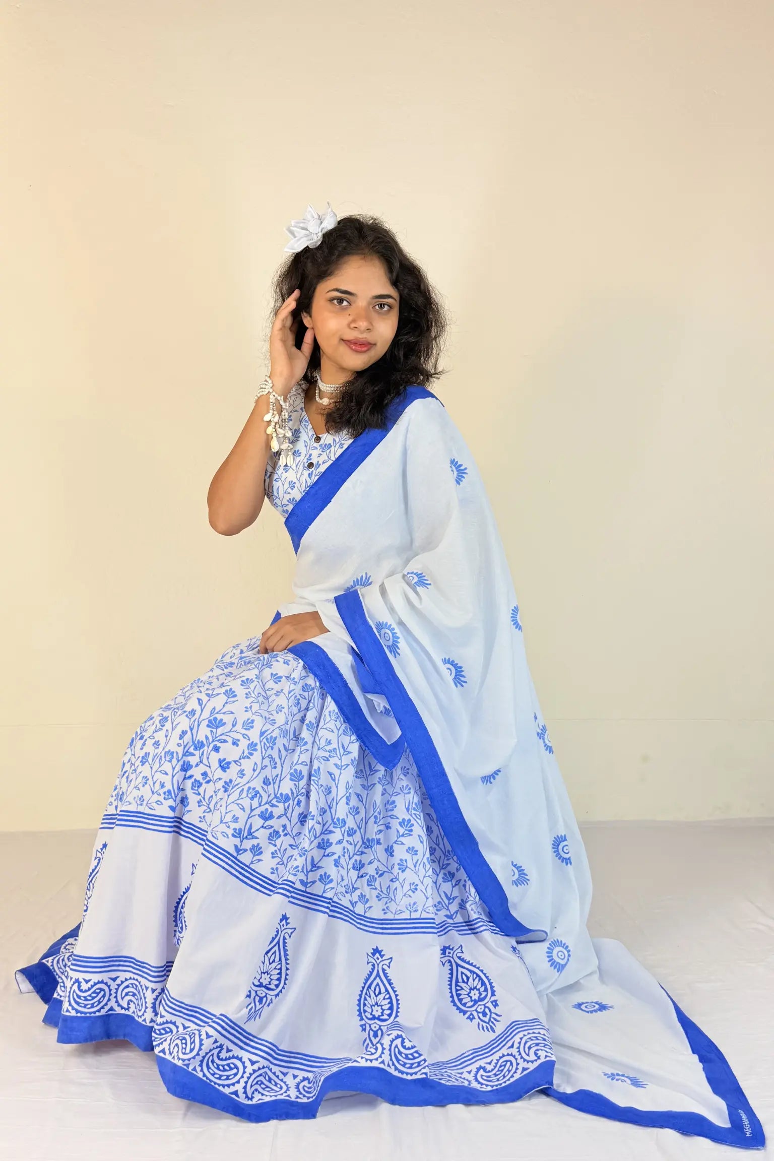 Woman wearing a purple Gopi Dress with white patterns on a plain background