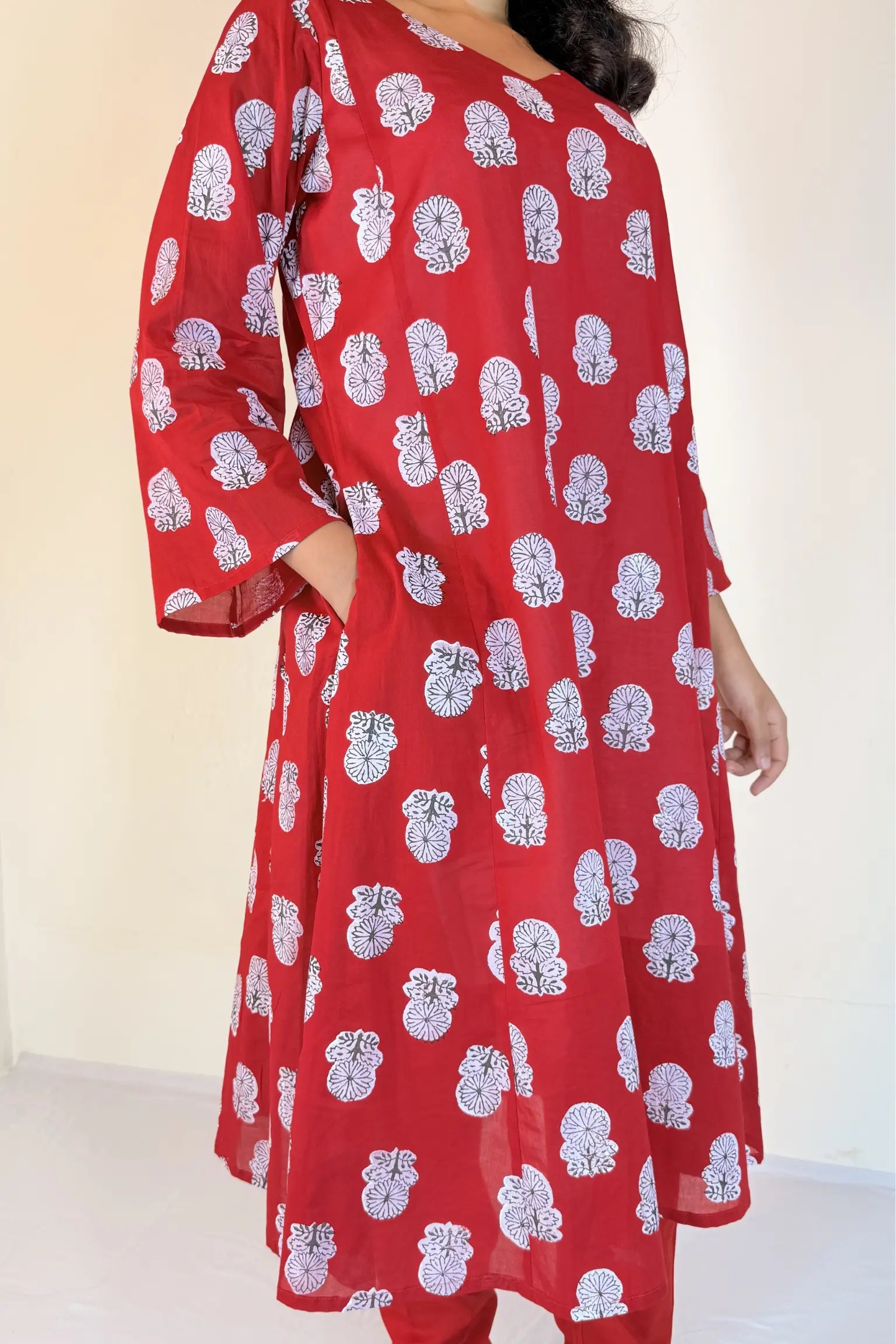 Red dress with white floral patterns on a plain background