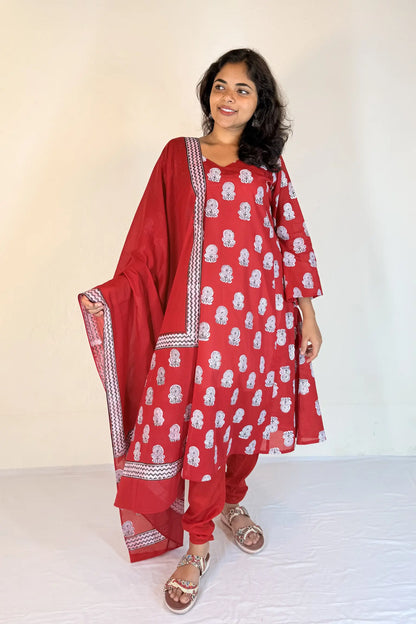 Woman wearing a red traditional outfit with white patterns on a white background