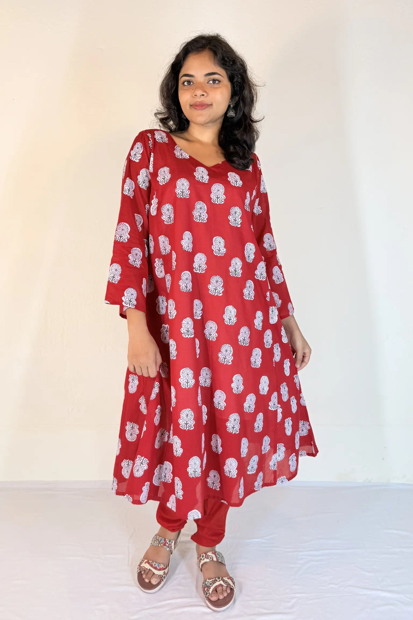Woman wearing a red floral dress against a white background