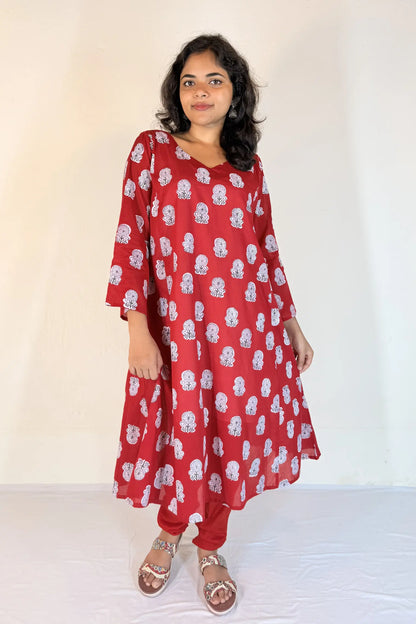 Woman wearing a red floral dress against a white background