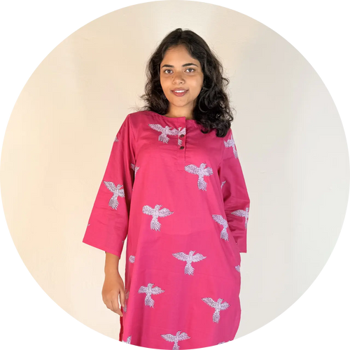 Woman wearing a pink dress with white patterns on a beige background
