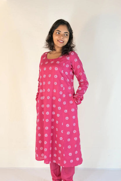 Woman wearing a pink floral outfit against a white background