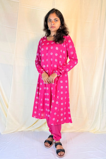 Woman wearing a pink floral outfit against a white background