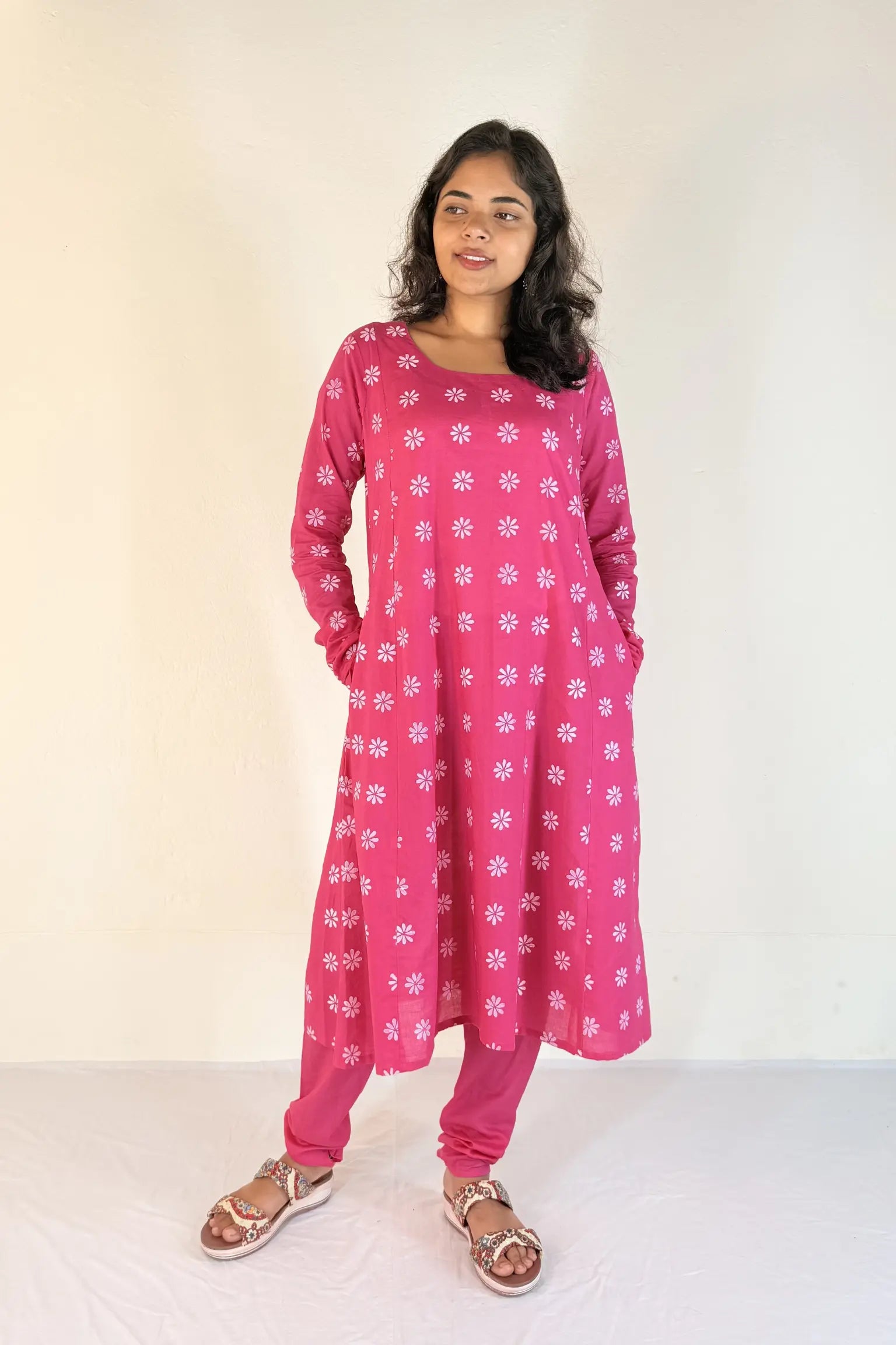 Woman wearing a pink floral dress against a white background
