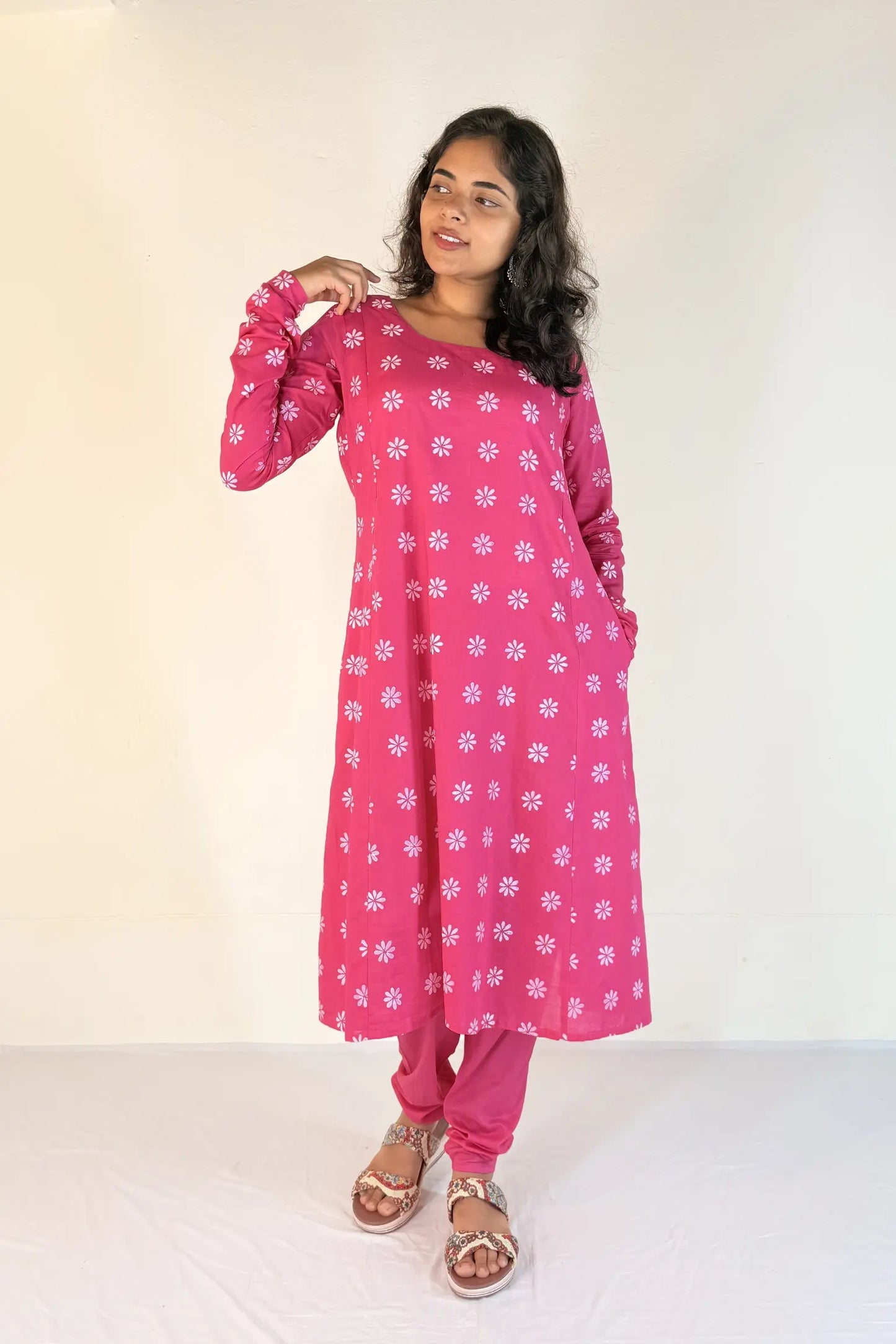 Woman wearing a pink floral outfit on a white background