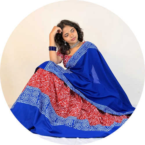 Woman wearing a blue and red Gopi Dress with white patterns on a beige background