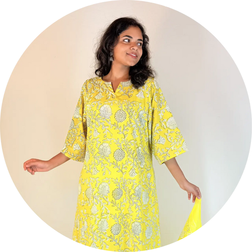 Woman wearing a yellow floral dress against a beige background