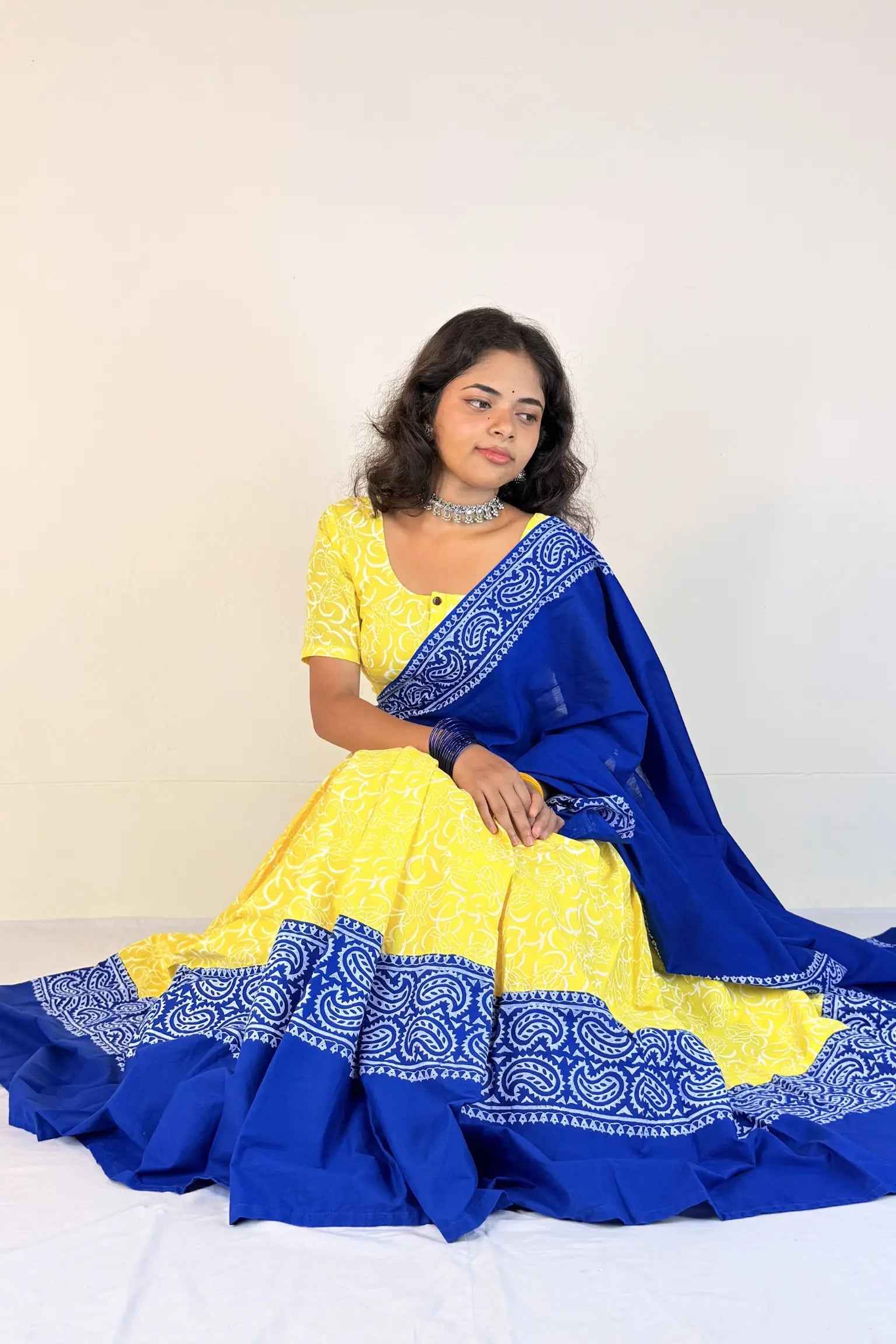 Woman wearing a yellow and blue Gopi Skirt Set with a white background