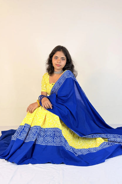 Woman wearing a yellow and blue traditional outfit with a white background