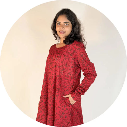Woman wearing a red dress with black floral pattern on a beige background