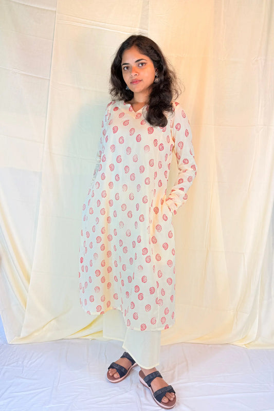 Woman wearing a light-colored kurta with floral patterns against a white background