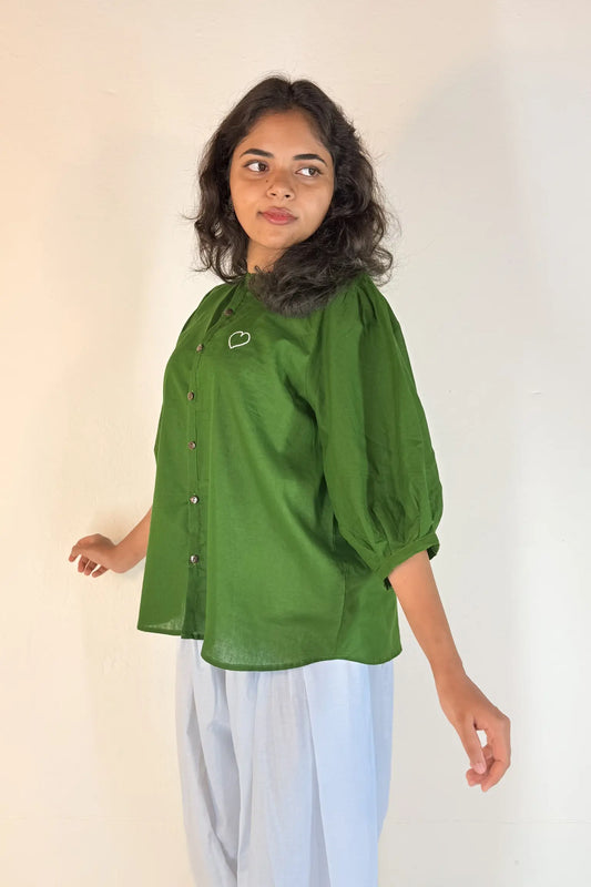 Woman wearing a green blouse with a plain background