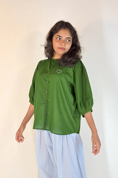 Woman wearing a green blouse with a plain background