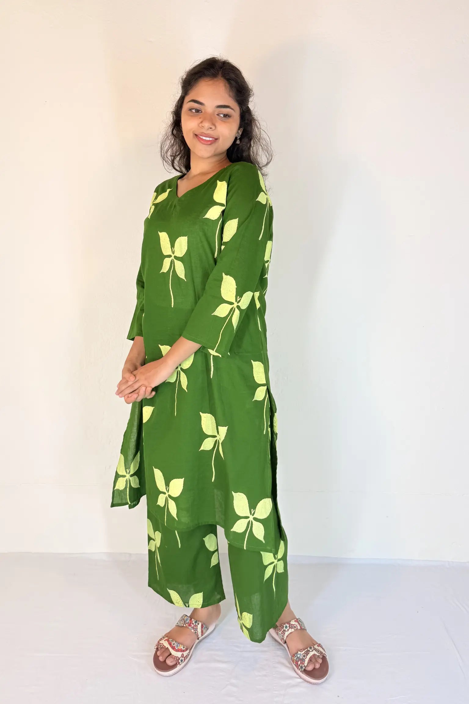 Woman wearing a green floral dress against a white background