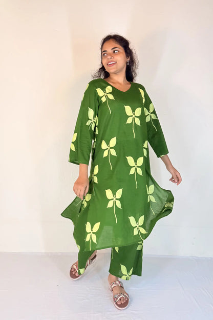 Woman wearing a green dress with leaf patterns on a white background