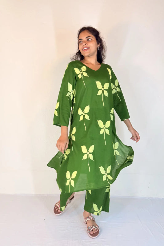 Woman wearing a green dress with leaf patterns on a white background