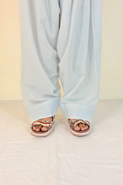 Light blue pants worn by a person on a white floor with a beige wall background